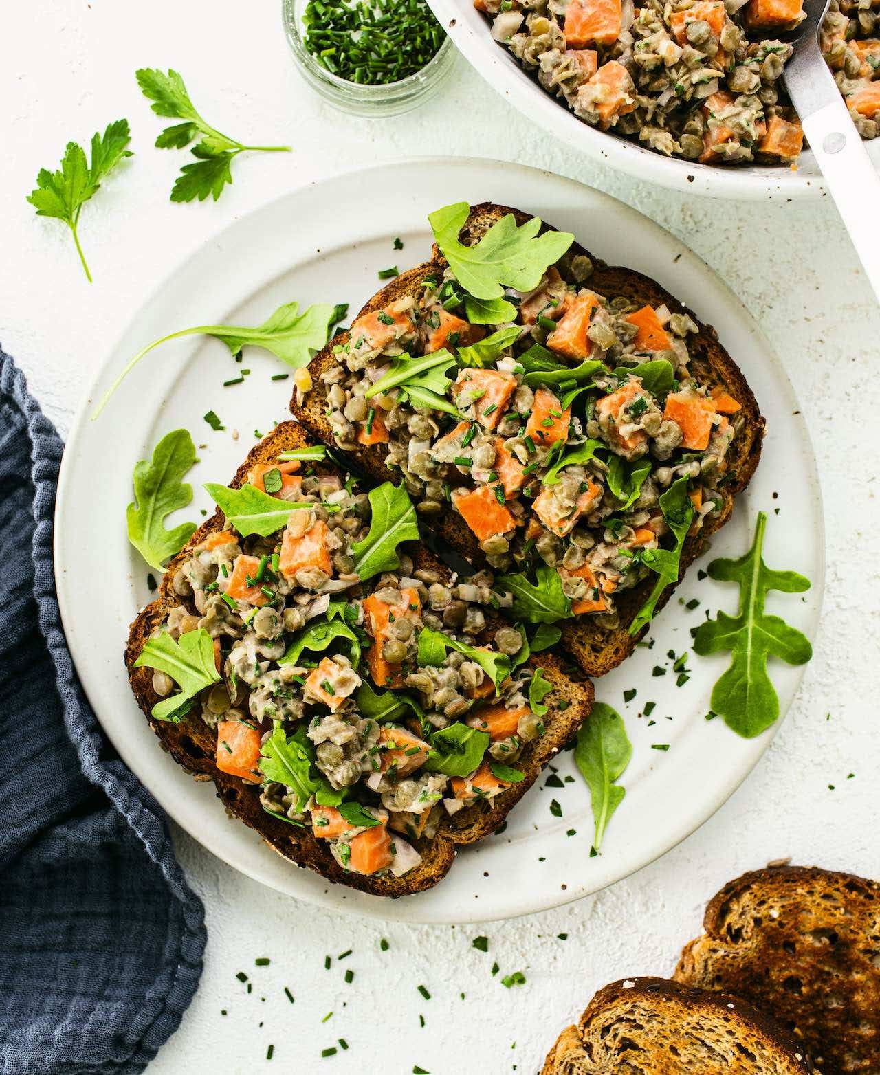 To slices of whole grain toast topped with Maple Mustard Lentils, Sweet Potatoes, and Herbs