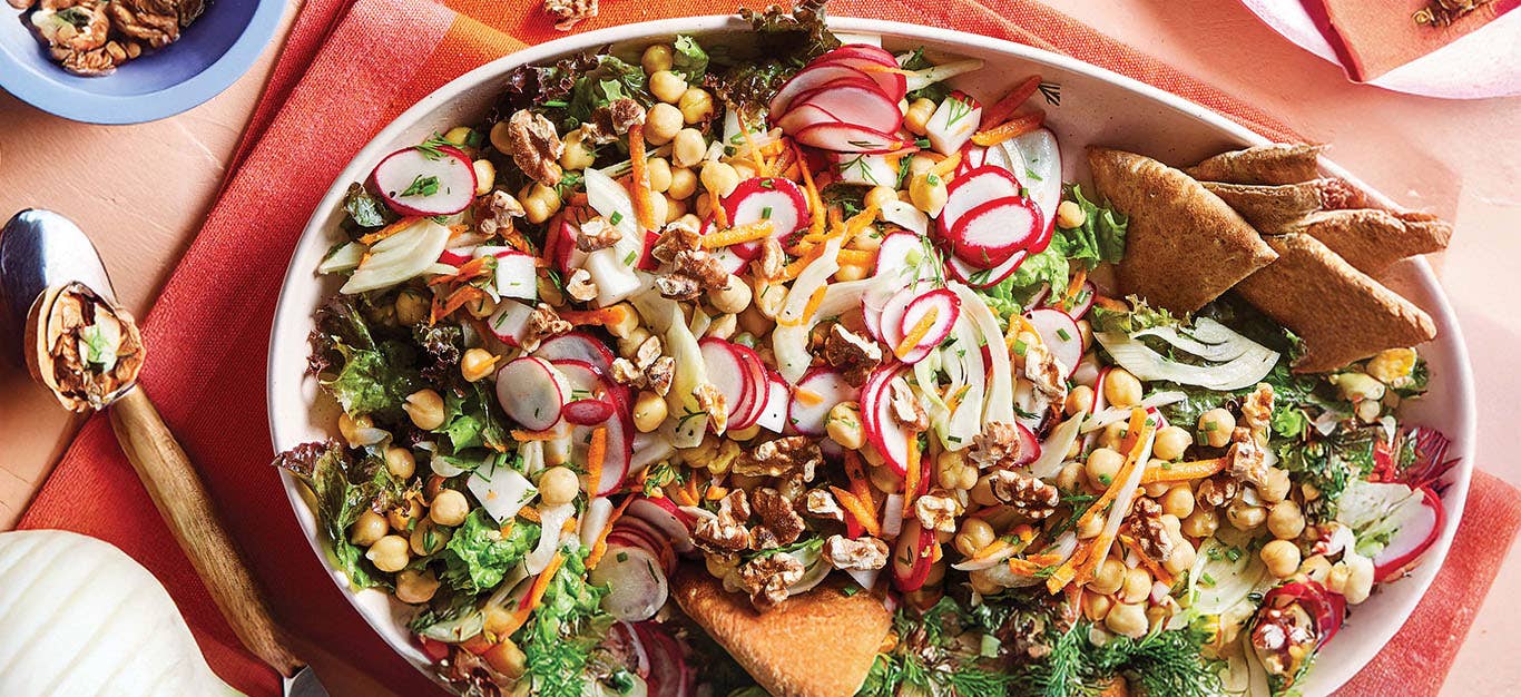 Chickpea, Fennel and Radish Salad on a large white serving platter on a red and pink checked kitchen towel
